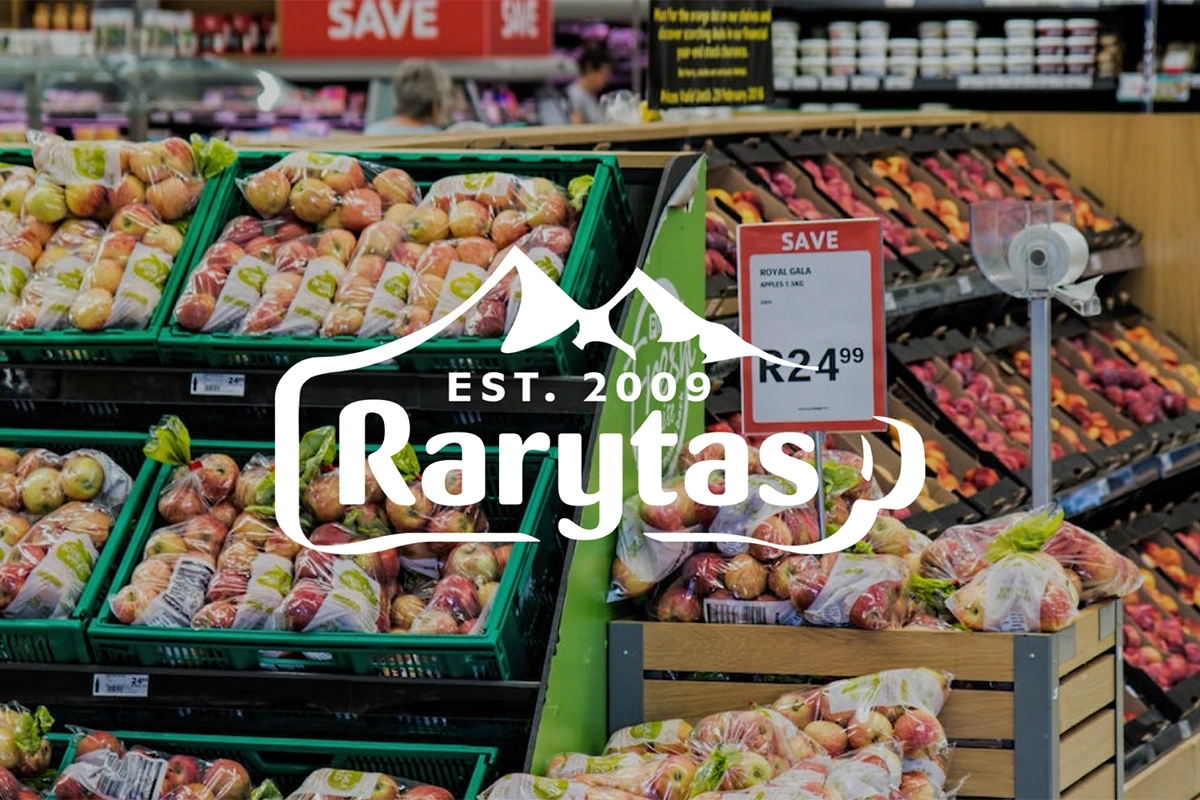 Logo Rarytas przedstawia nazwę w otoczce inspirowanej górami, sugerując naturalność i świeżość produktów. Napis „EST. 2009” podkreśla doświadczenie marki.