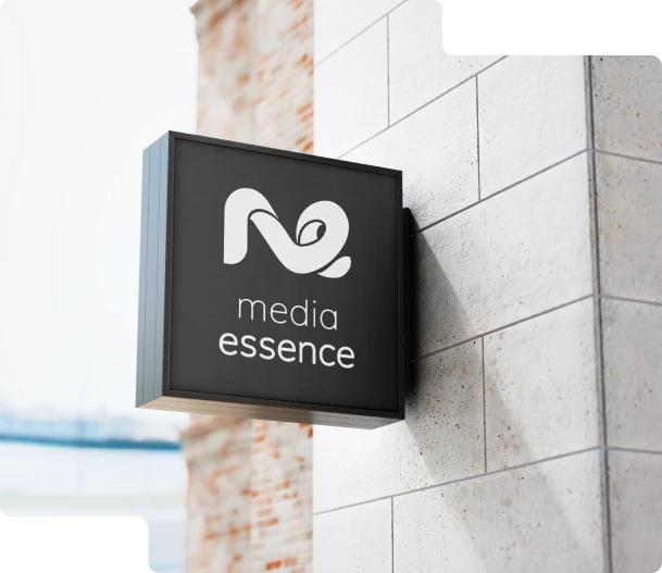 Reklama świetlna Media Essence – podświetlany szyld na budynku, biały napis na czarnym tle